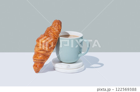 Fresh croissant and up of cappuccino or latte coffee on a marble stands on a green background 122569388