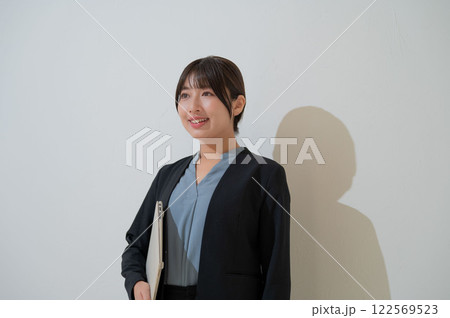 パソコンを持って微笑む日本人ビジネスウーマン パソコンを持って微笑む日本人ビジネスウーマン 122569523