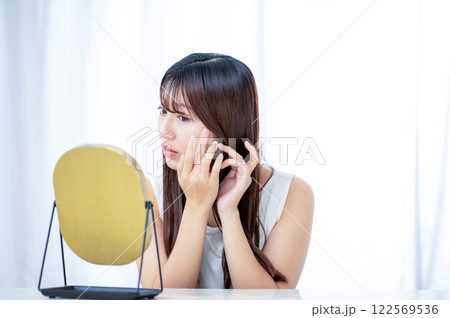 鏡で肌を確認する日本人女性 122569536