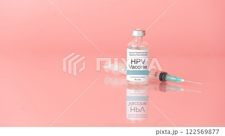 Human papillomavirus (HPV) vaccine bottle with syringe on pink background. HPV vaccine protects against certain types of HPV that can cause cervical cancer. 122569877