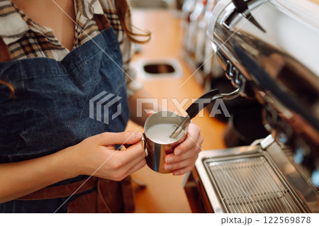 Portrait of a young barista woman making fresh coffee. Takeaway food. Small business concept. Portrait of a young barista woman making fresh coffee. Takeaway food. Small business concept. 122569878