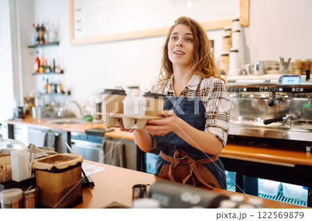 Female barista holding disposable takeaway cups. Business concept. Drinks to go. Female barista holding disposable takeaway cups. Business concept. Drinks to go. 122569879