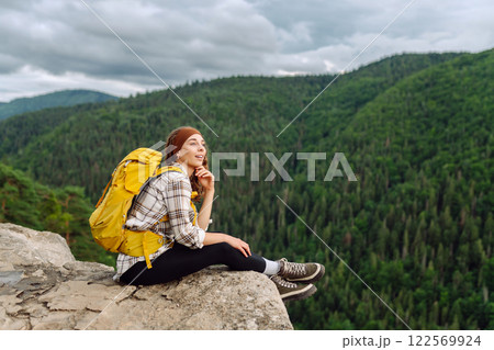 Woman on mountain peak. Landscape with sporty young woman, green hills. Nature. Travel and tourism. 122569924
