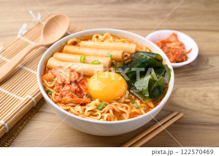 Spicy noodles soup with Tteokbokki, Wakame seaweed and fresh egg yok eating with kimchi cabbage Spicy noodles soup with Tteokbokki, Wakame seaweed and fresh egg yok eating with kimchi cabbage 122570469