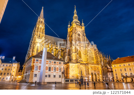 St Vitus Cathedral stands majestically by night in Prague Castle, showcasing intricate architecture and stunning lighting against a dark blue sky, drawing visitors to admire its beauty. St Vitus Cathedral stands majestically by night in Prague Castle, showcasing intricate architecture and stunning lighting against a dark blue sky, drawing visitors to admire its beauty. 122571044