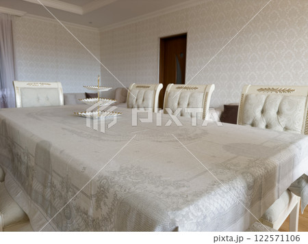 Old style white wooden table and chairs with tablecloth for eating Old style white wooden table and chairs with tablecloth for eating 122571106