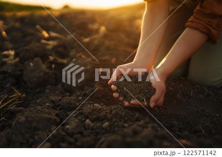 Female hands touching soil on the field. Agriculture, gardening or ecology concept 122571142