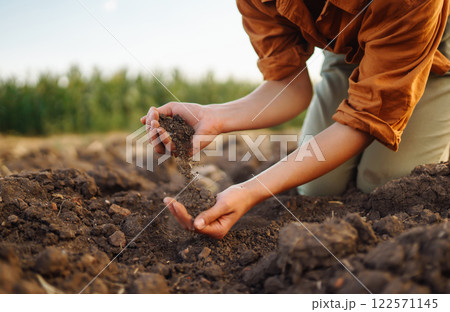Expert hand of farmer woman checking soil health before growth seed of vegetable. Gardening concept. Expert hand of farmer woman checking soil health before growth seed of vegetable. Gardening concept. 122571145