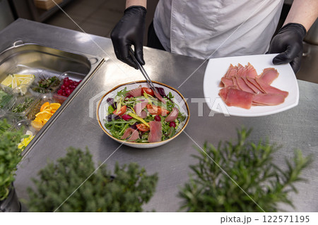 Professional chef adding tuna slices 122571195