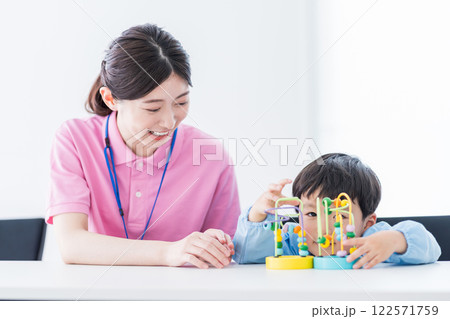 知育玩具でトレーニングする保育園児と保育士  122571759