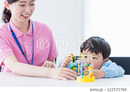 知育玩具でトレーニングする保育園児と保育士  122571760
