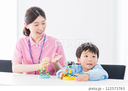知育玩具でトレーニングする保育園児と保育士  122571763