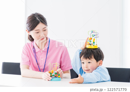 知育玩具でトレーニングする保育園児と保育士  122571770