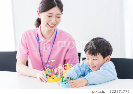 知育玩具でトレーニングする保育園児と保育士  122571775