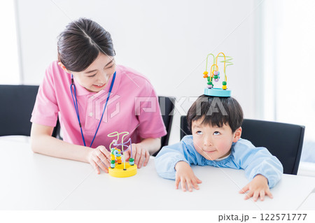 知育玩具でトレーニングする保育園児と保育士 122571777