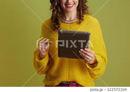 happy fit woman using digital tablet on green background happy fit woman using digital tablet on green background 122572104