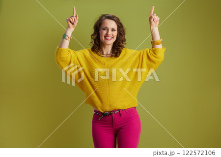 happy healthy woman pointing isolated on green happy healthy woman pointing isolated on green 122572106