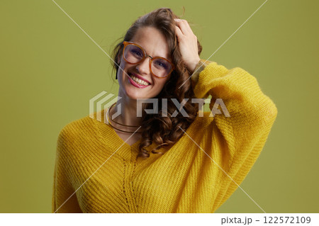 Portrait of happy healthy woman in sweater and glasses on green Portrait of happy healthy woman in sweater and glasses on green 122572109