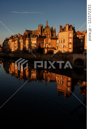 Golden hour cityscape with historic buildings reflected in calm water Golden hour cityscape with historic buildings reflected in calm water 122572355