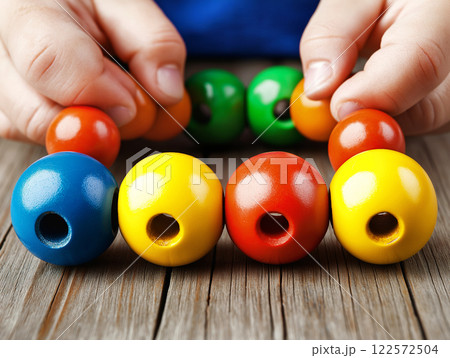 Child playing with colorful wooden beads 122572504