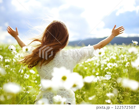 Woman enjoying freedom in a field of daisies 122572507