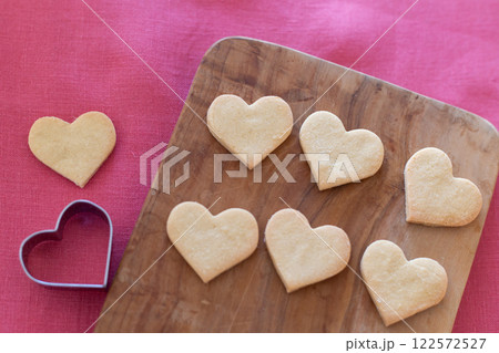 木製ボードの上に並んだハート型の手作りクッキー 122572527