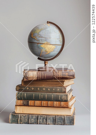Globe on a stack of vintage books, on a gray background. Education concept. Back to school. Globe on a stack of vintage books, on a gray background. Education concept. Back to school. 122574439