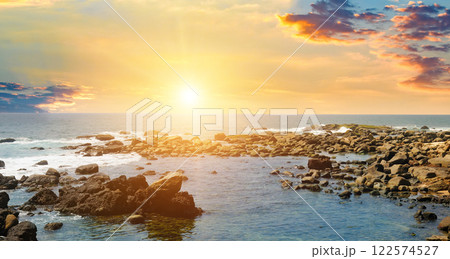 Seascape with beautiful waves, rocky shore and bright sunrise. Concept - vacation and travel. Seascape with beautiful waves, rocky shore and bright sunrise. Concept - vacation and travel. 122574527