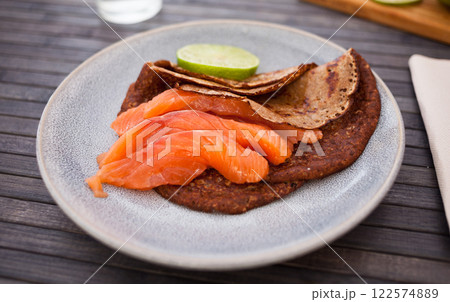 Salted salmon fillet with buckwheat pancakes and lime Salted salmon fillet with buckwheat pancakes and lime 122574889