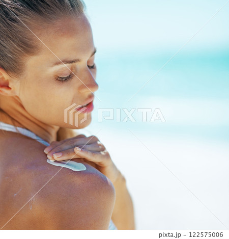 Young woman applying sun screen creme 122575006