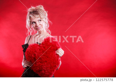 Woman holds big red heart love symbol 122575778