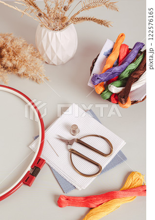 Set of equipment for cross stitching on a gray background vertical view 122576165