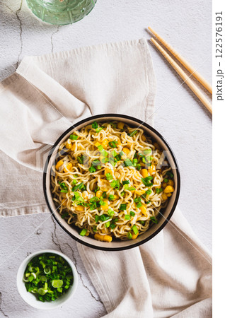 A bowl of instant noodles and vegetables on the table top and vertical view 122576191