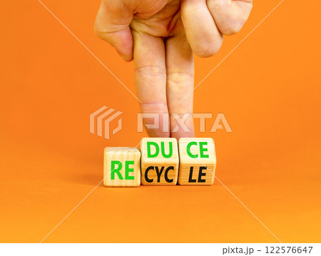 Reduce or recycle symbol. Concept words Reduce Recycle on wooden block. Beautiful orange table orange background. Businessman hand. Business reduce or recycle concept. Copy space. 122576647