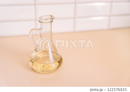 Olive oil in a bottle on texture background Olive oil in a bottle on texture background 122576833
