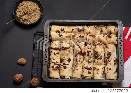 Delicious Chocolate Drizzled Crepe on Black Tray 122577096