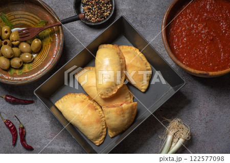 Golden Empanadas with Salsa on a Wooden Board Golden Empanadas with Salsa on a Wooden Board 122577098