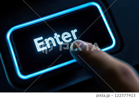 Illuminated Blue Enter Key on Black Keyboard with Finger Pressing Button 122577413