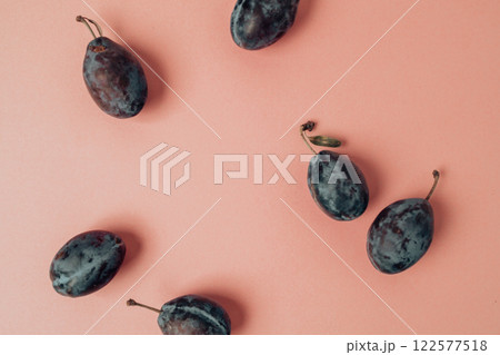 Top view photo of whole plums on isolated pastel pink background 122577518