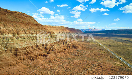 Aerial of Red Rock Formations and Desert Road in Utah 122579070
