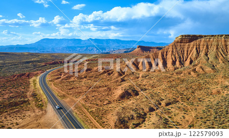 Aerial of Red Rock Formations and Winding Road in Utah Desert 122579093
