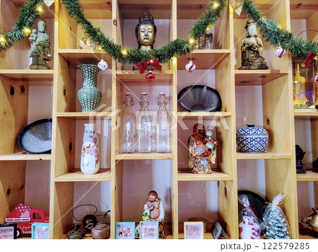 Cozy Festive Buddha Decor on Shelves with Warm Holiday Glow Eye-Level View Cozy Festive Buddha Decor on Shelves with Warm Holiday Glow Eye-Level View 122579285