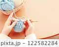 かぎ針編みで水色の毛糸を編む両手 122582284