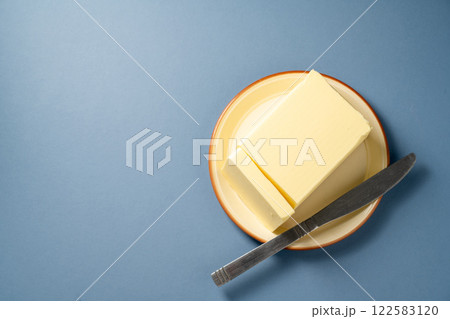 Butter block, grass-feed butter over wooden background. Vitamin D and source of fat Butter block, grass-feed butter over wooden background. Vitamin D and source of fat 122583120