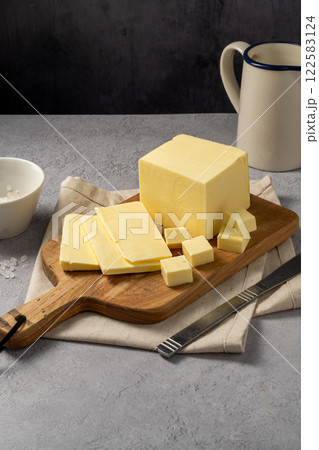 Butter block, grass-feed butter slices over wood cutting board. Vitamin D and source of fat  122583124