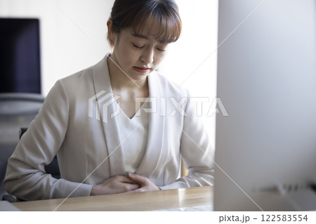 仕事中にお腹が痛いビジネスウーマン 122583554