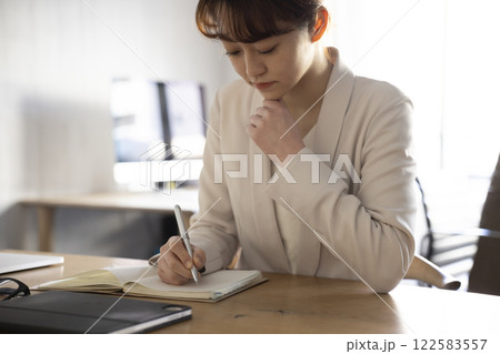 手帳に記入するビジネスウーマン 122583557