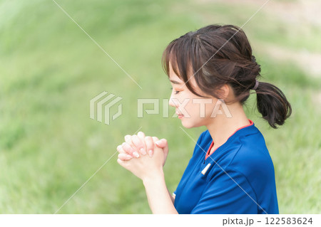 祈るように日本代表を応援するサッカーファン・サポーターの日本人女性 122583624