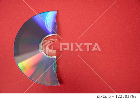 赤い背景に破損した光ディスク 122583768
