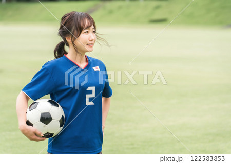 サッカーボールを持ちながら笑顔でサッカーするファン・サポーターの日本人女性 122583853